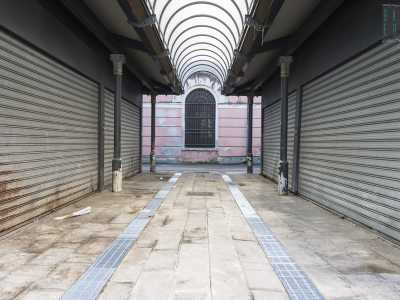 Circondata da un�alta ringhiera si apre una piazzola occupata da una fila ordinata di chioschetti in metallo nero collegati tra loro da coperture ad arco: le loro saracinesche sono per� tutte ben serrate e nessuno si aggira per gli stretti vialetti su cui si affacciano